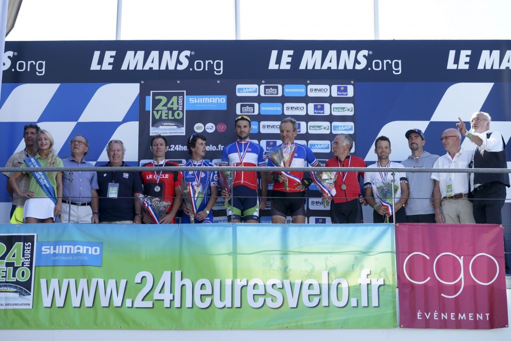 Sur le podium des 24 Heures du Mans, les deux champions de France 2015, Christophe Darne et Michel Quéruel, entourés de leurs dauphins, Josselin Clair, Frédéric Millet, Sylvain Thomas, Didier Paillat, de Miss 24 Heures, de Christian Chéron et Jean-Claude Virfeu (UJSF Ouest), Roger Legeay, Roger Bordeau, Luc Alphand et Jean Réveillon (ancien directeur de France 2)